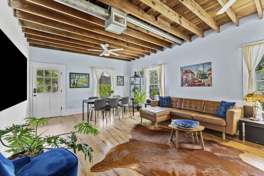 Living room with exposed wood beams, antique furnishings, and warm lighting in St. Augustine home