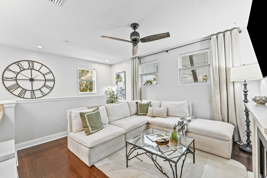 Spacious living room with wood floors, electric fireplace, and open layout in a St. Augustine home