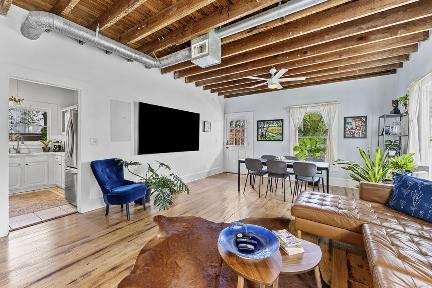 Living room with exposed wood beams, antique furnishings, and warm lighting in St. Augustine home