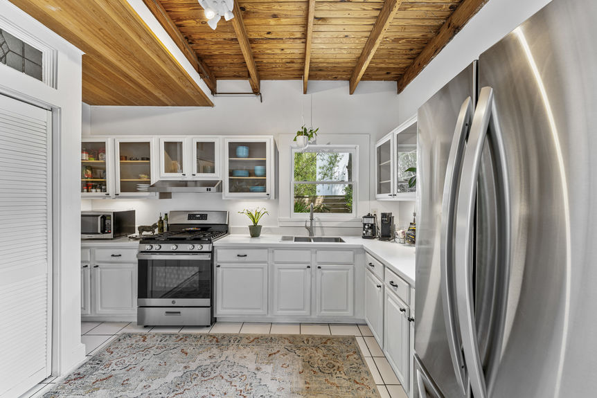 Open-concept dining space with antique table and kitchen featuring gas stove in St. Augustine home