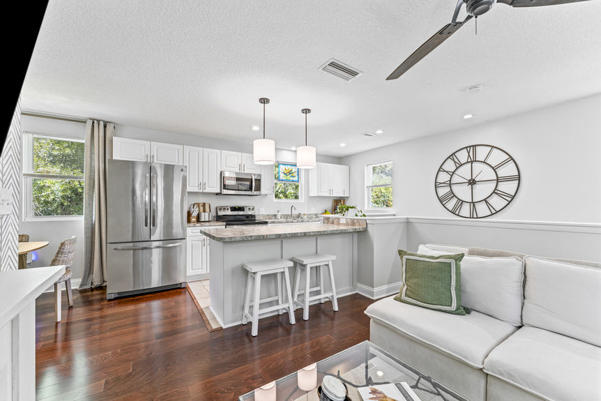 Bright modern kitchen with stainless steel appliances, white cabinetry, and marble countertops in a St. Augustine home