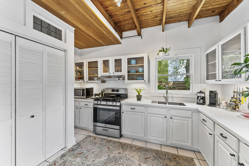 Open-concept dining space with antique table and kitchen featuring gas stove in St. Augustine home