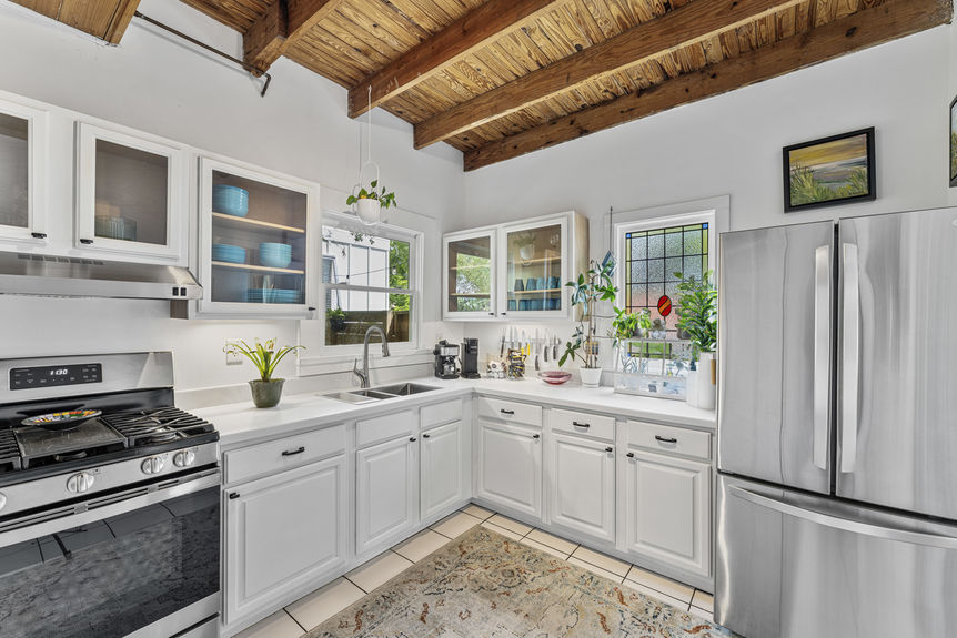 Open-concept dining space with antique table and kitchen featuring gas stove in St. Augustine home