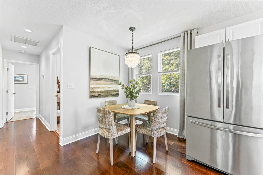 Bright modern kitchen with stainless steel appliances, white cabinetry, and marble countertops in a St. Augustine home