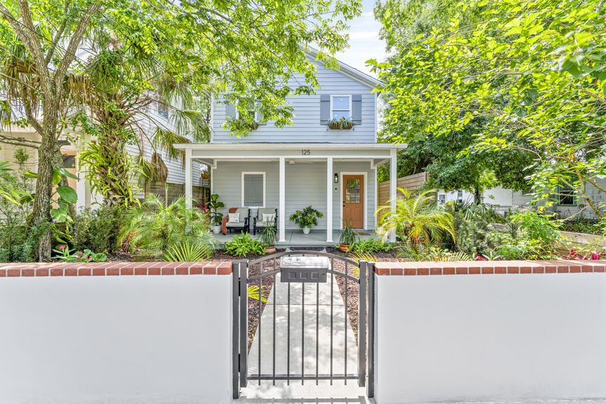 Front exterior of a modern white stilted cottage with a welcoming porch in Lincolnville, St. Augustine