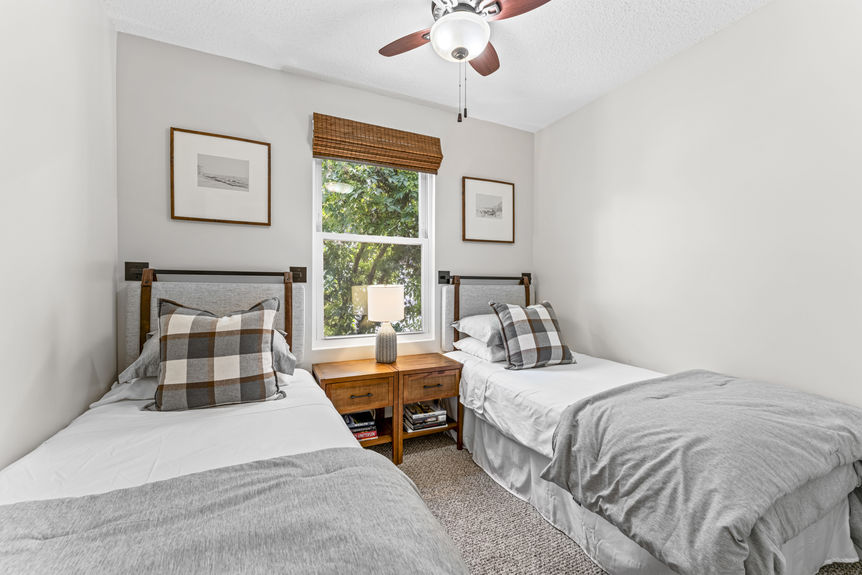Second bedroom with wood floors, soft natural light, and minimalist décor in a Lincolnville home