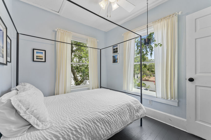 Upper-level bedroom with large window and cozy decor in Lincolnville St. Augustine property