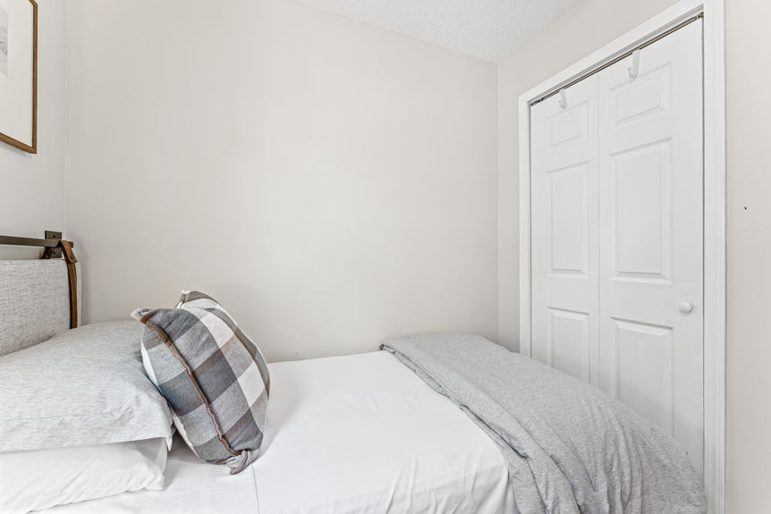 Bright and airy primary bedroom with large windows, wood flooring, and neutral décor in a St. Augustine home