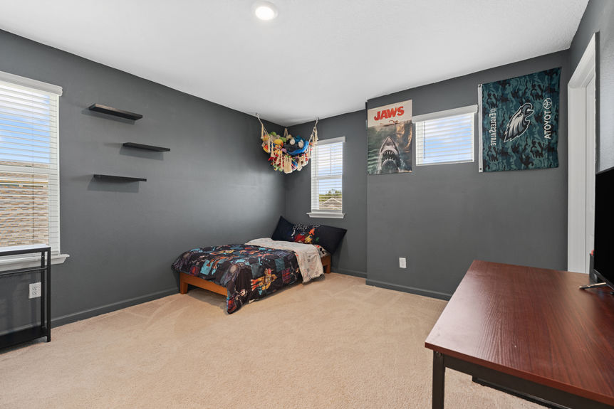 Guest bedroom with large window, neutral walls, and plush carpeting in St Augustine Lakes home