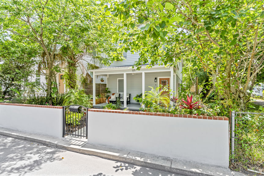 Front exterior of a modern white stilted cottage with a welcoming porch in Lincolnville, St. Augustine