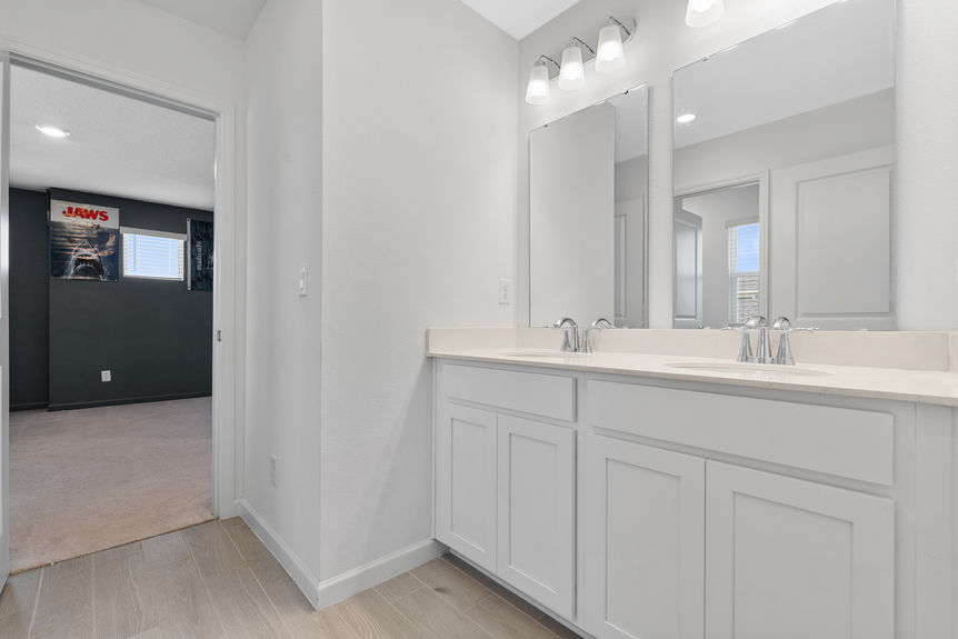 Modern bathroom with dual sinks, large mirror, and glass walk-in shower in St Augustine home
