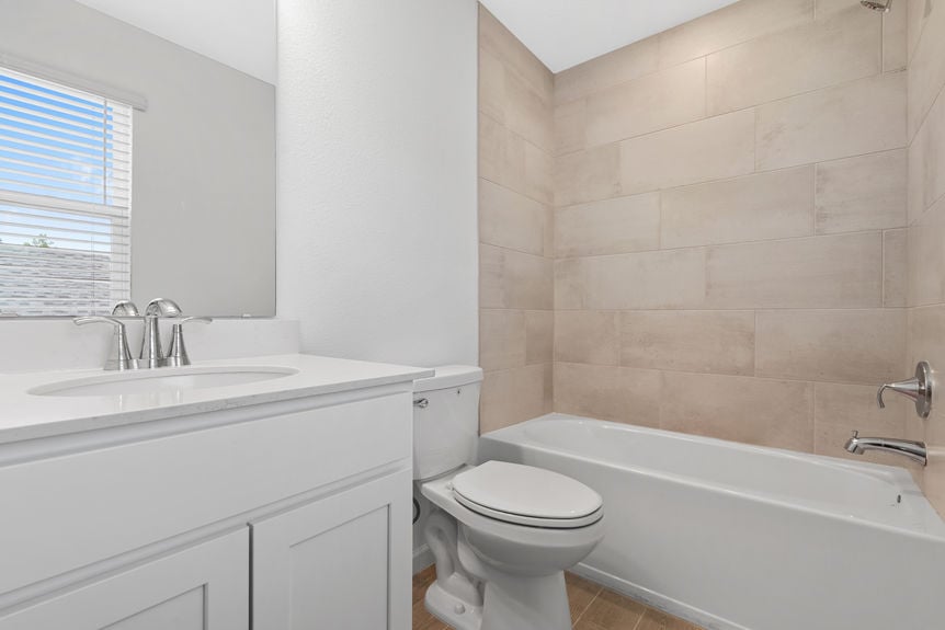 Modern bathroom with dual sinks, large mirror, and glass walk-in shower in St Augustine home