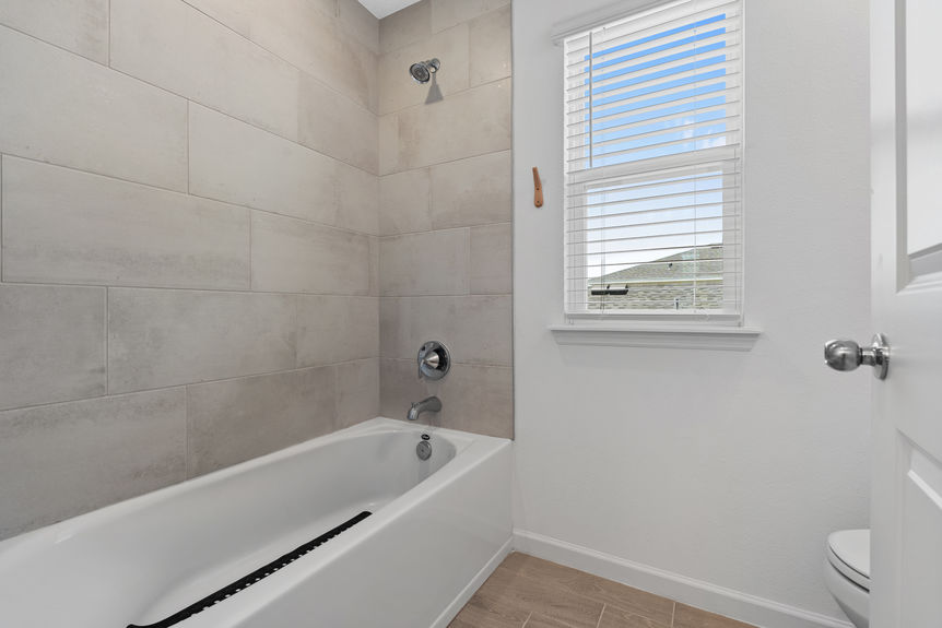Modern bathroom with dual sinks, large mirror, and glass walk-in shower in St Augustine home