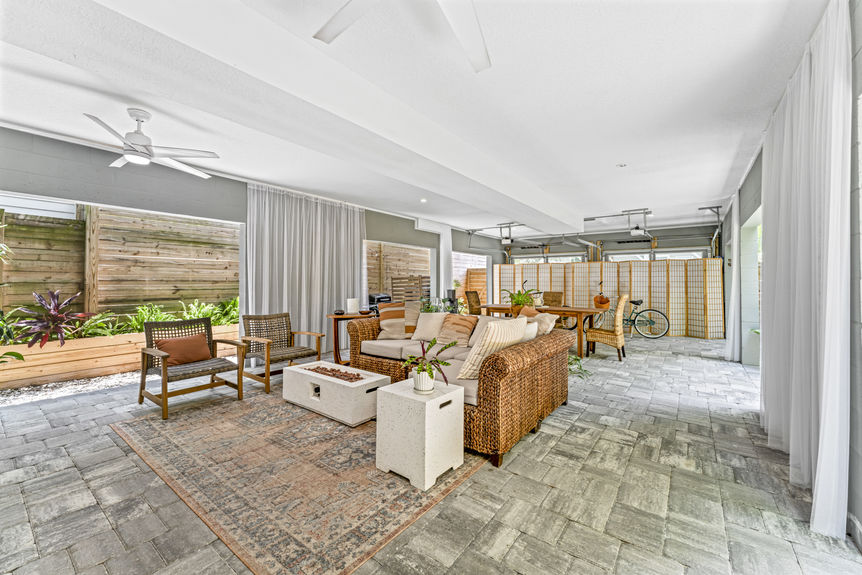 Multi-use garage with seating area, dining table, and ceiling fans in a Lincolnville home in St. Augustine