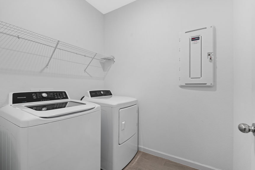 Laundry room in St Augustine home with built-in shelves and space for washer and dryer