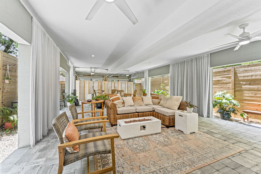 Multi-use garage with seating area, dining table, and ceiling fans in a Lincolnville home in St. Augustine