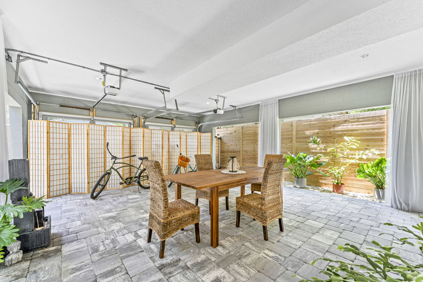 Multi-use garage with seating area, dining table, and ceiling fans in a Lincolnville home in St. Augustine
