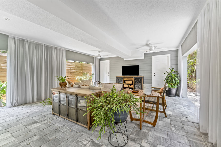 Multi-use garage with seating area, dining table, and ceiling fans in a Lincolnville home in St. Augustine