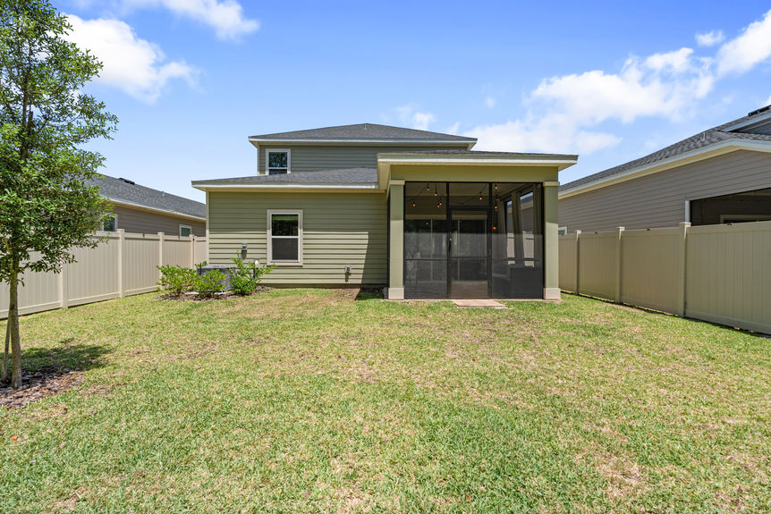 Outdoor covered patio with seating, hammock, and sliding glass doors leading to the backyard and preserve in St Augustine