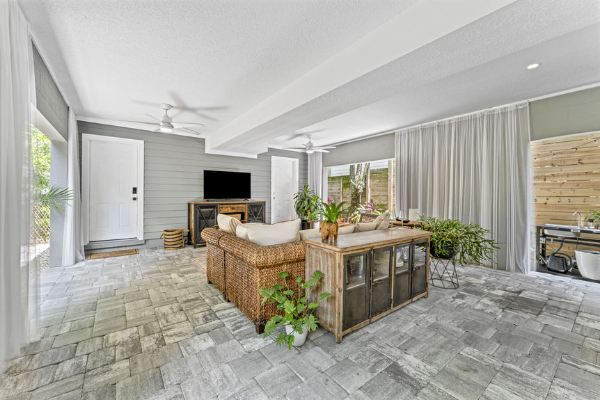 Multi-use garage with seating area, dining table, and ceiling fans in a Lincolnville home in St. Augustine