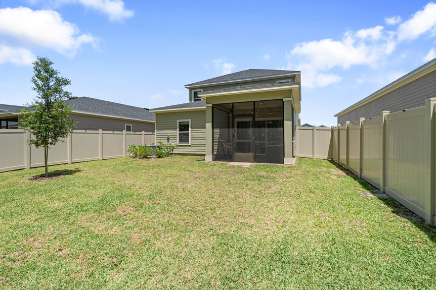 Outdoor covered patio with seating, hammock, and sliding glass doors leading to the backyard and preserve in St Augustine