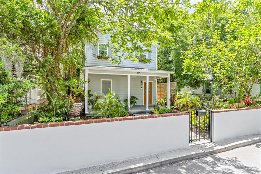 Front exterior of a modern white stilted cottage with a welcoming porch in Lincolnville, St. Augustine