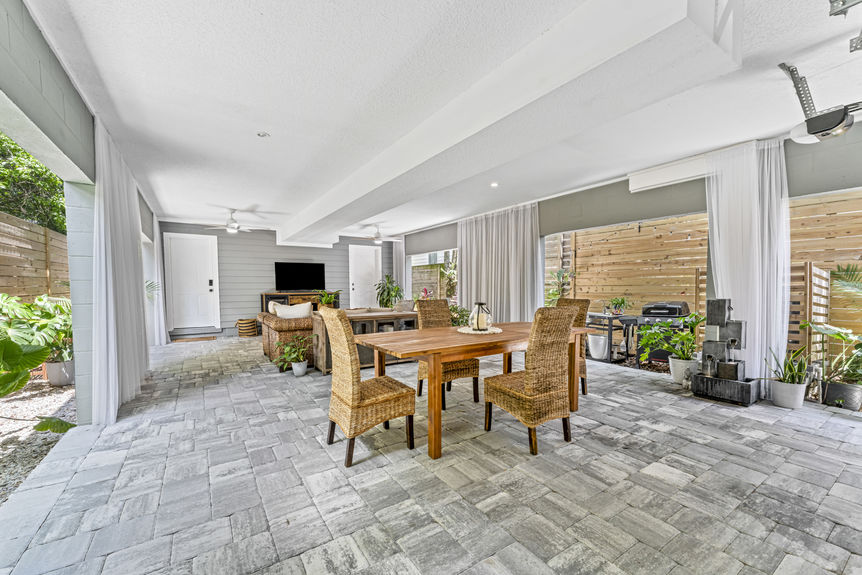 Multi-use garage with seating area, dining table, and ceiling fans in a Lincolnville home in St. Augustine