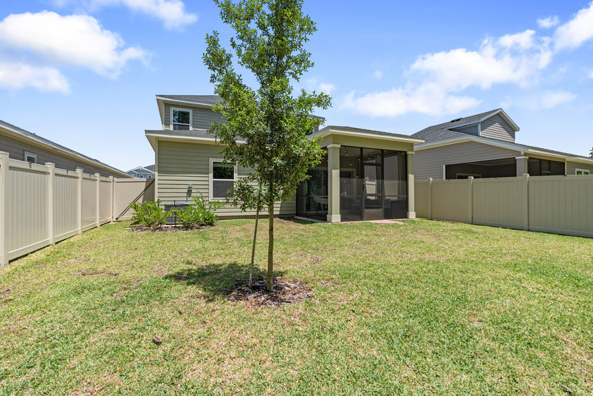 Outdoor covered patio with seating, hammock, and sliding glass doors leading to the backyard and preserve in St Augustine