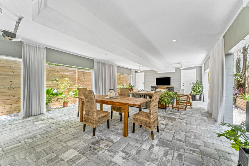 Multi-use garage with seating area, dining table, and ceiling fans in a Lincolnville home in St. Augustine