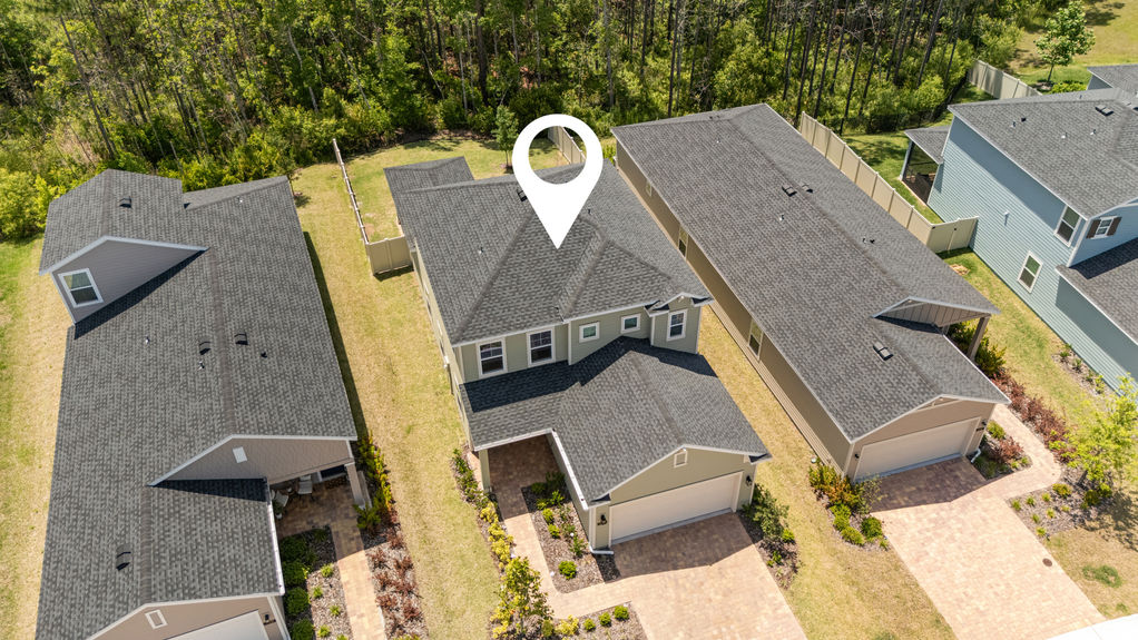Overhead view of two-story home in St Augustine Lakes with preserve behind and nearby homes in peaceful neighborhood