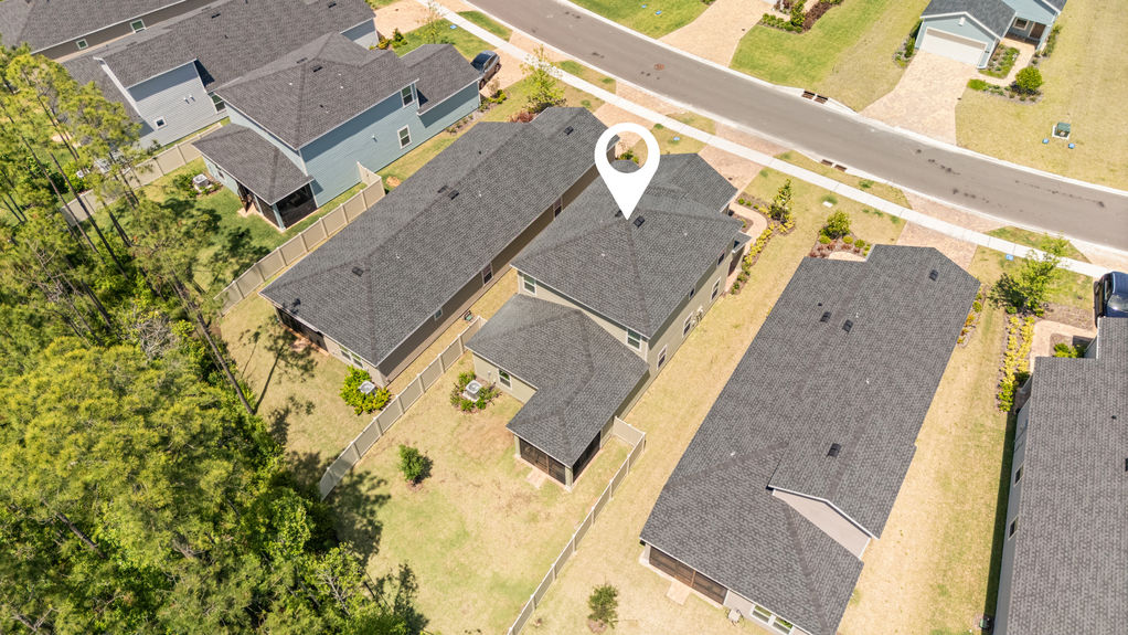 Overhead view of two-story home in St Augustine Lakes with preserve behind and nearby homes in peaceful neighborhood