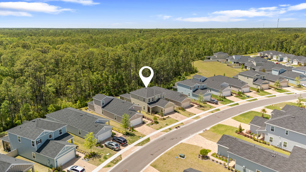 Aerial view of two-story home in St Augustine Lakes with preserve behind and nearby homes in peaceful neighborhood