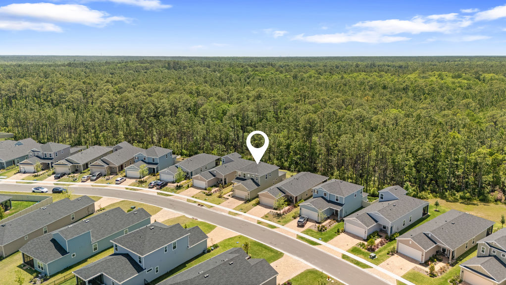 Aerial view of two-story home in St Augustine Lakes with preserve behind and nearby homes in peaceful neighborhood