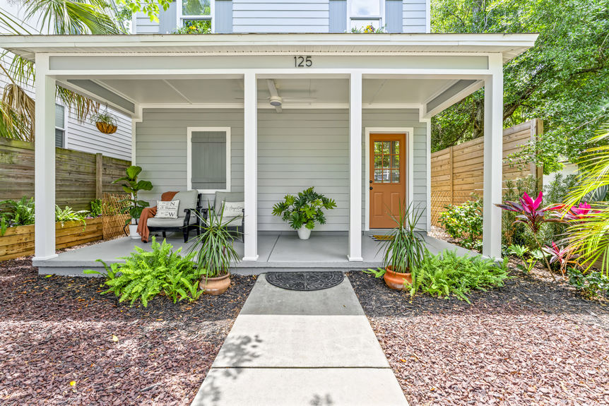 Front exterior of a modern white stilted cottage with a welcoming porch in Lincolnville, St. Augustine