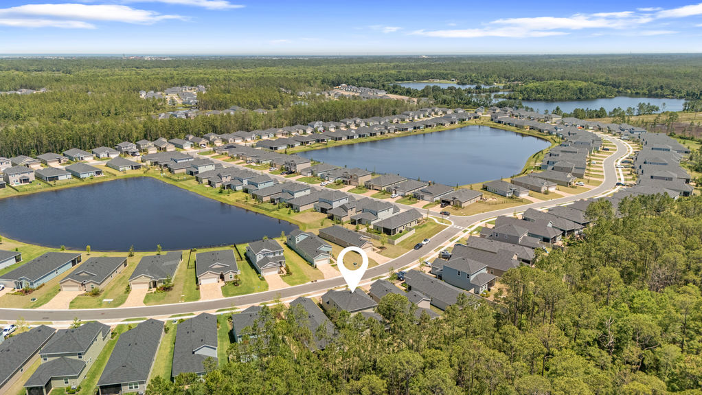 Aerial view of two-story home in St Augustine Lakes with preserve behind and nearby homes in peaceful neighborhood