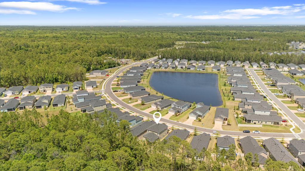 Aerial view of two-story home in St Augustine Lakes with preserve behind and nearby homes in peaceful neighborhood
