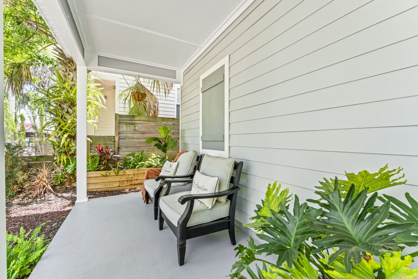Front exterior of a modern white stilted cottage with a welcoming porch in Lincolnville, St. Augustine
