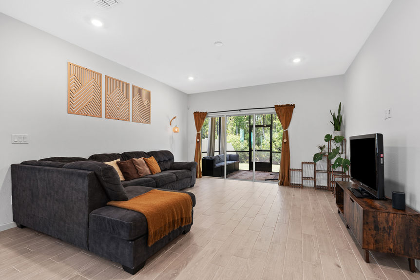 Spacious kitchen with stainless steel appliances, green cabinetry, and view into open living area in a St Augustine home