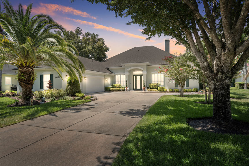 Front view of a luxury home in St Augustine Florida with palm trees and double garage