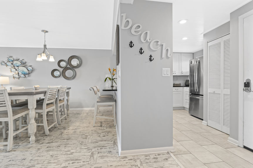 Stackable washer and dryer next to stainless fridge in condo unit
