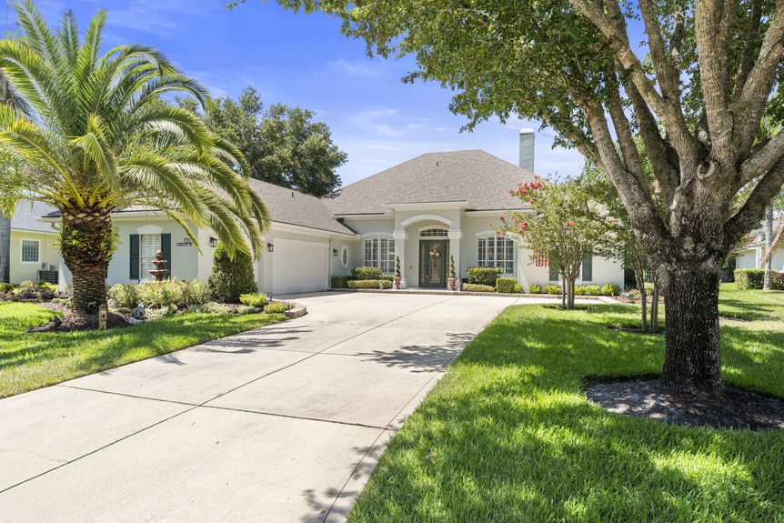 Front view of a luxury home in St Augustine Florida with palm trees and double garage
