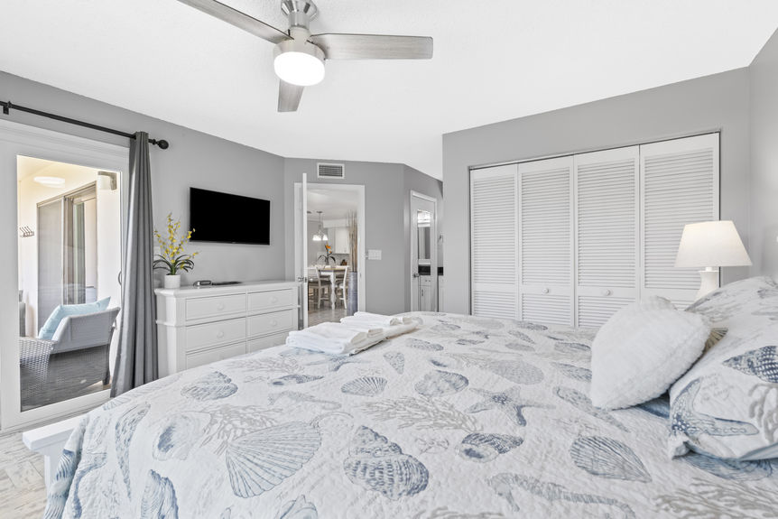 Bright bedroom with coastal décor and palm tree view