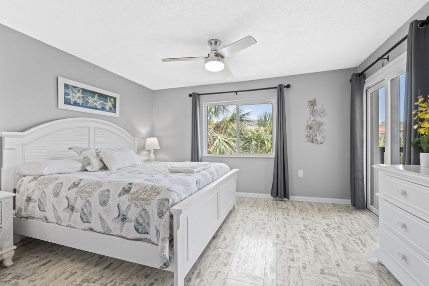 Bright bedroom with coastal décor and palm tree view