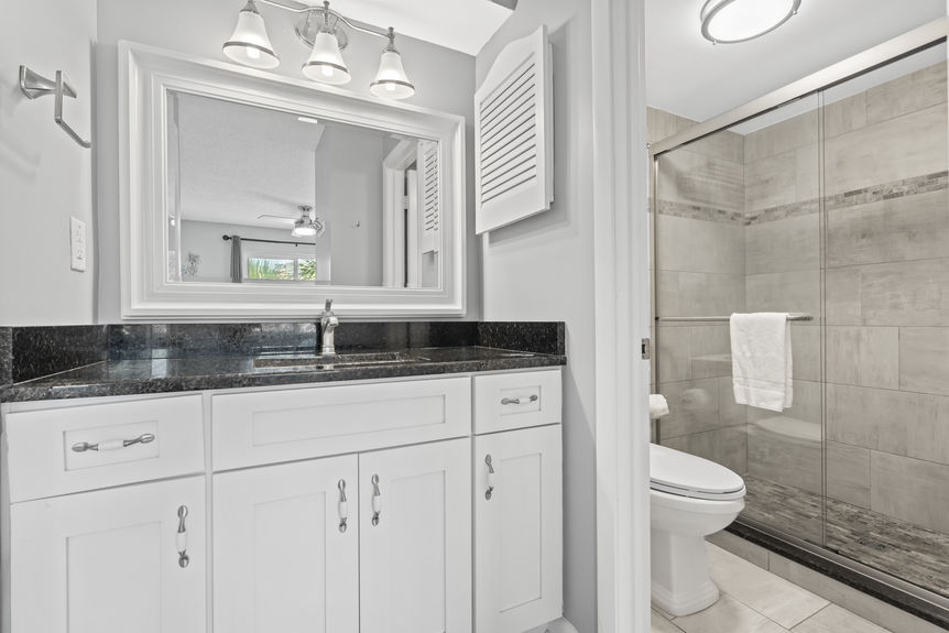 Modern bathroom with tiled shower and granite vanity in St. Augustine Beach, Florida
