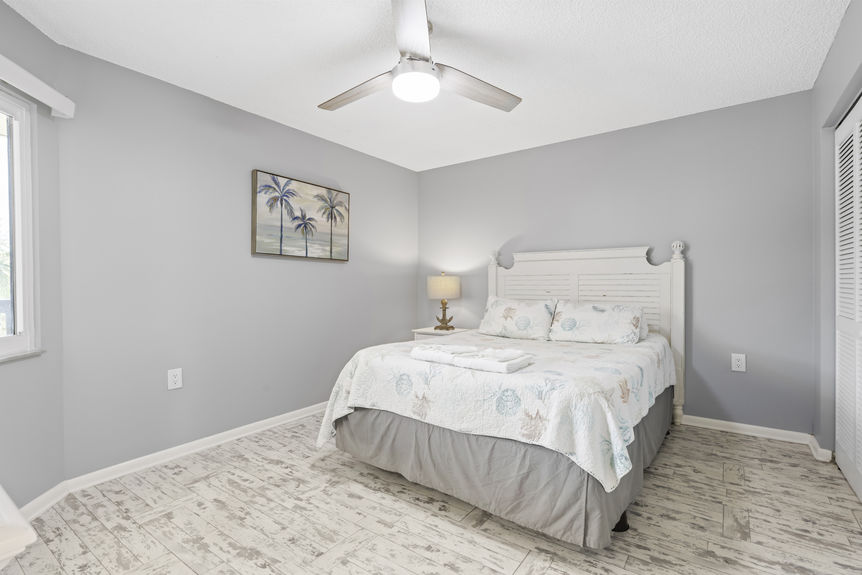 Bright bedroom with coastal décor and palm tree view