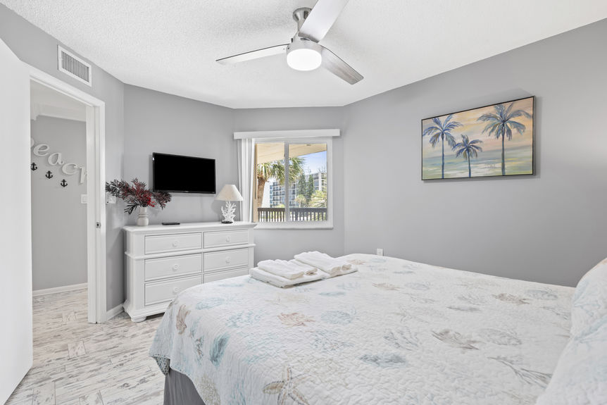 Bright bedroom with coastal décor and palm tree view