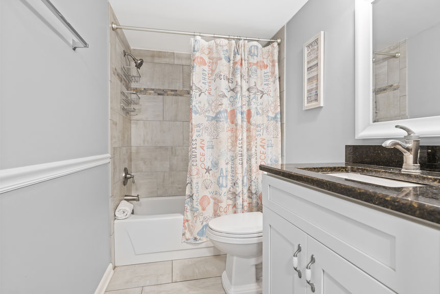 Modern bathroom with tiled shower and granite vanity in St. Augustine Beach, Florida
