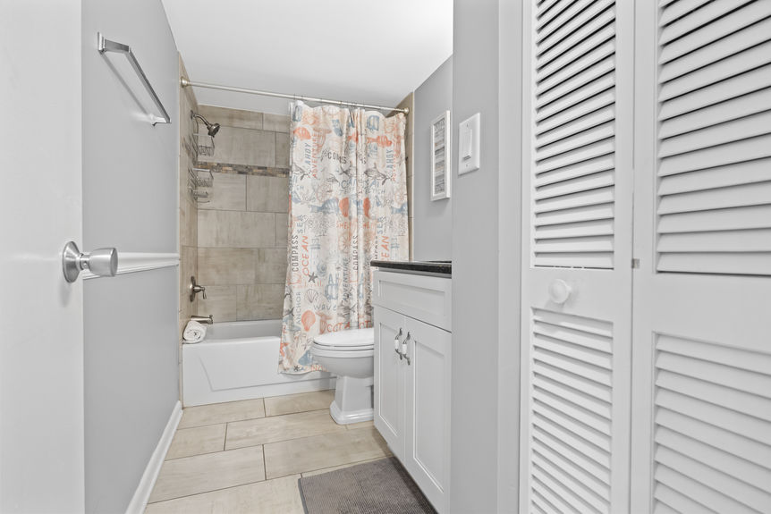 Modern bathroom with tiled shower and granite vanity in St. Augustine Beach, Florida