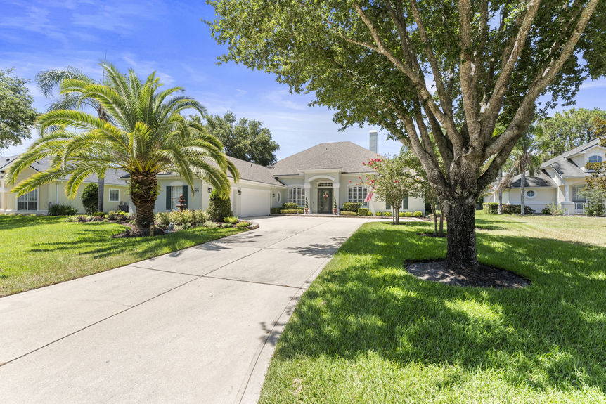 Front view of a luxury home in St Augustine Florida with palm trees and double garage