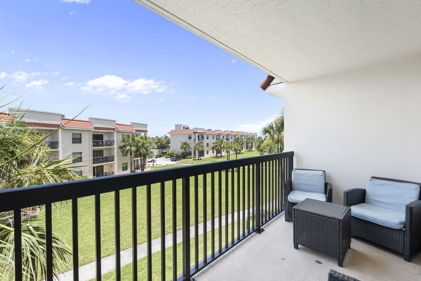 Ocean Village Club condo balcony with patio seating and palm tree views in St Augustine Florida